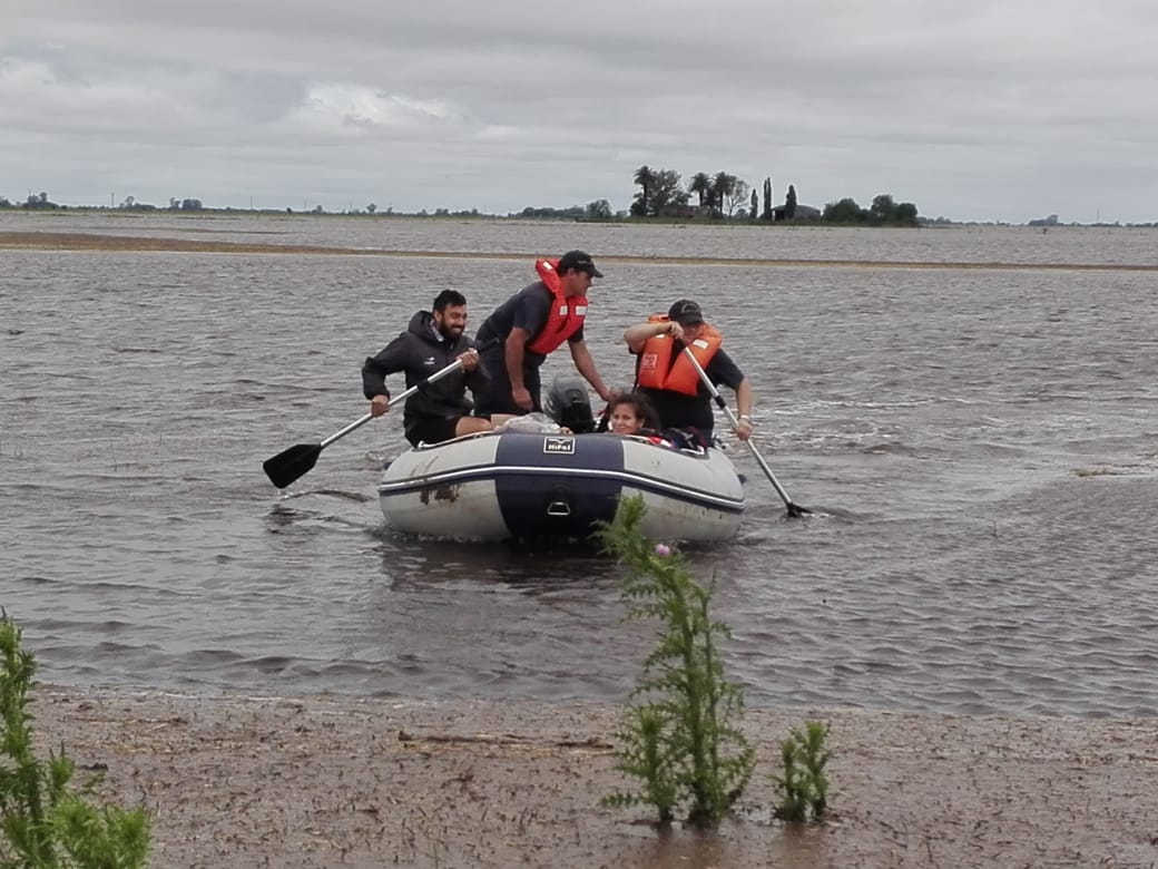 Bomberos rescataron a tres personas de un campo inundado